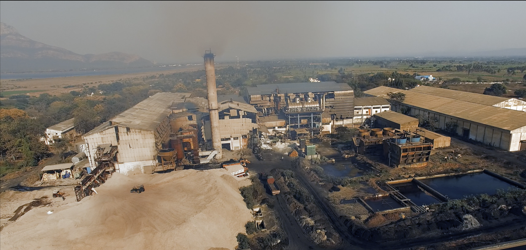 BVisuals- Ad film & video production featuring a drone shot of a factory landscape with machinery and industrial operations in the foreground.